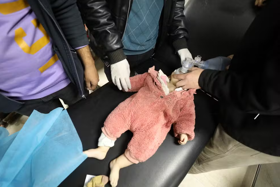 Bebê palestino é atendido após ser atingido por paraquedas lançado com carregamento de ajuda humanitária — Foto: Anadolu Agency via Reuters