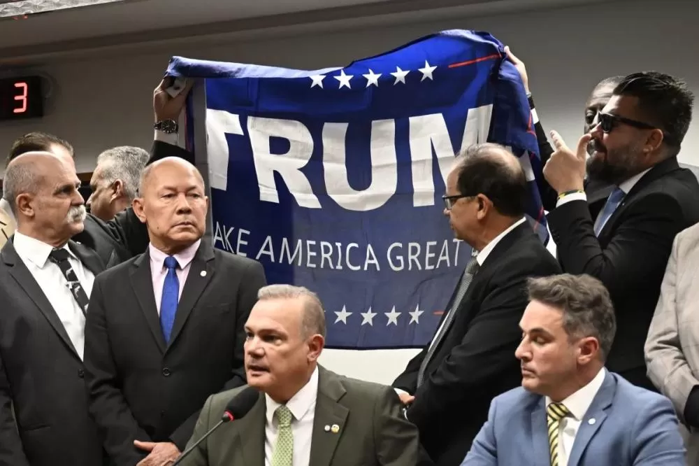 Deputados levantam bandeira em apoio ao presidente dos Estados Unidos, Donald Trump, na Comissão de Segurança Pública da Câmara Foto: Mateus Bonomi